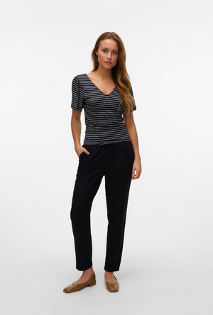 Front image of a model wearing the Milo ankle pants in black, by brand Vero moda