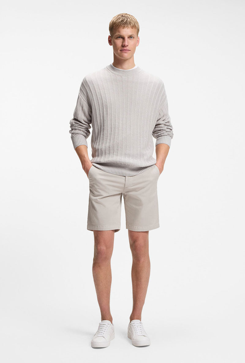 Front image of a model wearing Chino slim shorts in light grey, by brand Boss