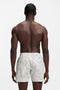 Back image of a model wearing the Piranha swimshorts in beige, by brand Boss