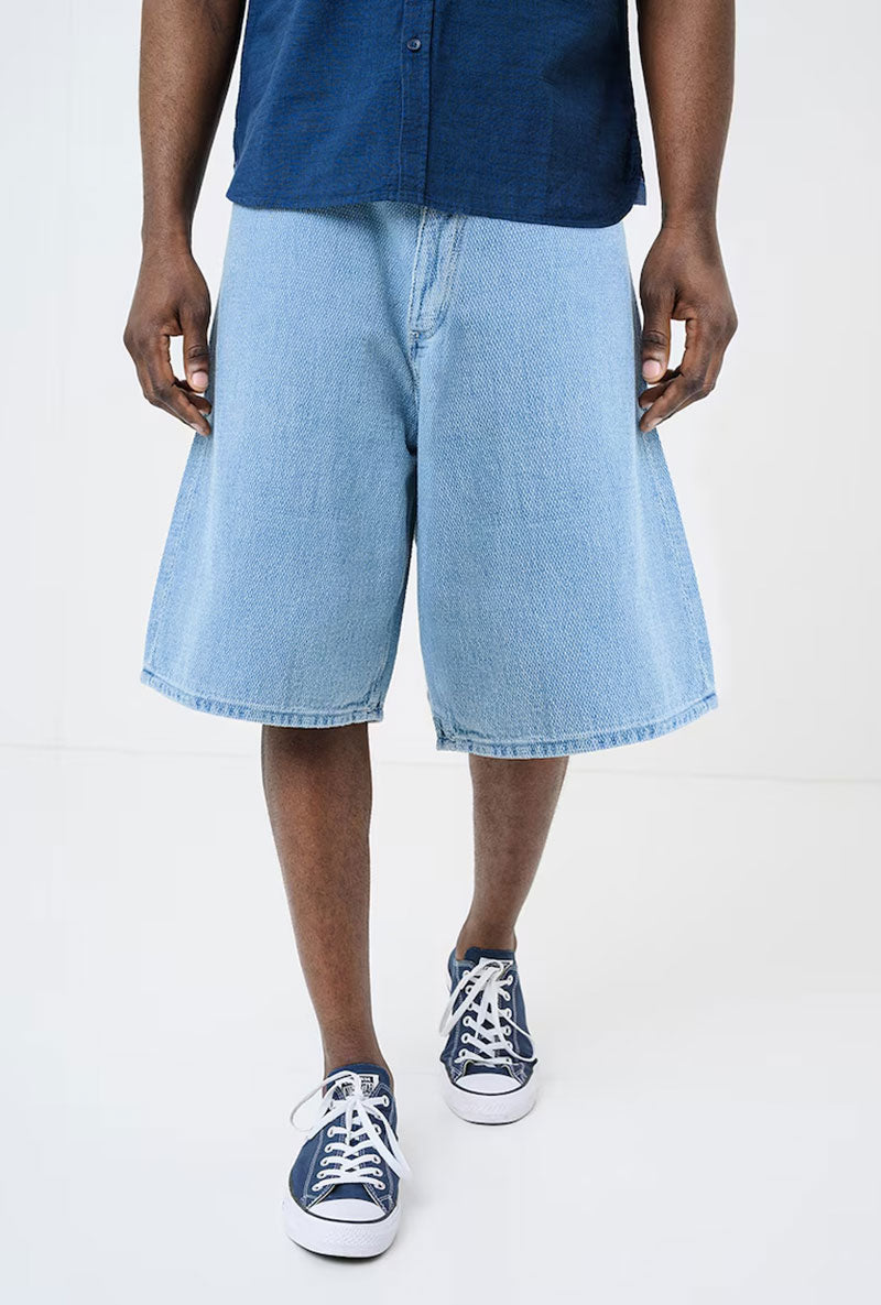 Front image of a model wearing Mason bermuda shorts in denim, by brand Hugo