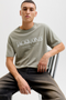 Front image of a model wearing the Jack and jones daytona print tee in khaki, by brand Jack&jones