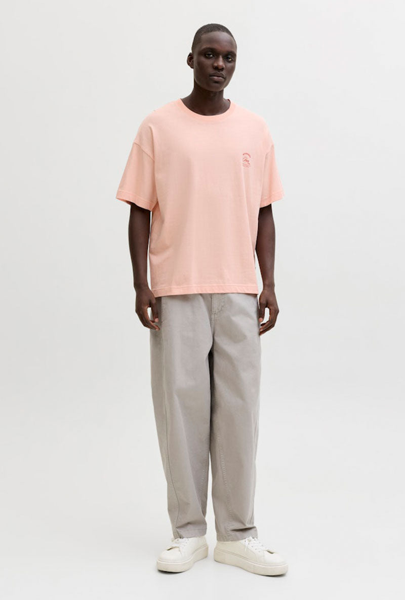 Front image of a model wearing Montauk back graphic tee in peach, by brand Jack&jones