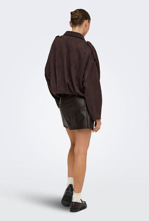 Back image of a model wearing the Ella pu mini skirt in black, by brand Jacqueline de yong