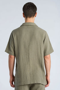 Back image of a model wearing the Cotton muslin resort shirt in sage, by brand Lindbergh