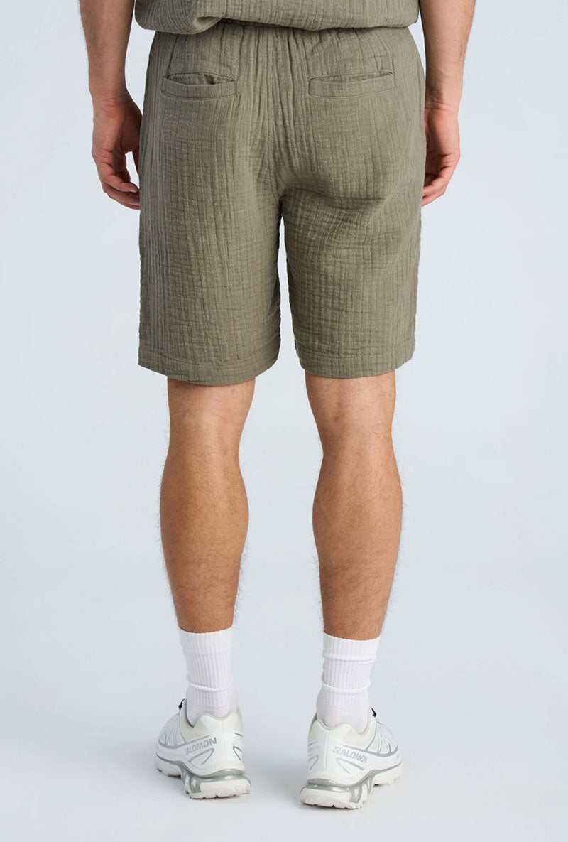Back image of a model wearing Cotton muslin shorts in sage, by brand Lindbergh