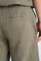 Back image of a model wearing the Cotton muslin shorts in sage, by brand Lindbergh