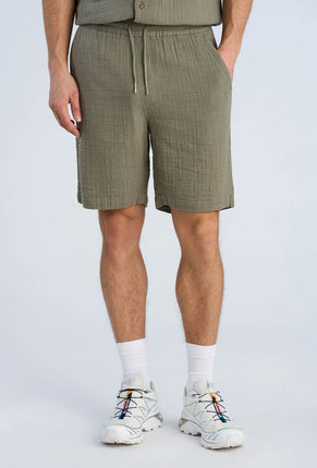 Front image of a model wearing Cotton muslin shorts in sage, by brand Lindbergh