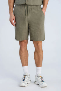 Front image of a model wearing the Cotton muslin shorts in sage, by brand Lindbergh