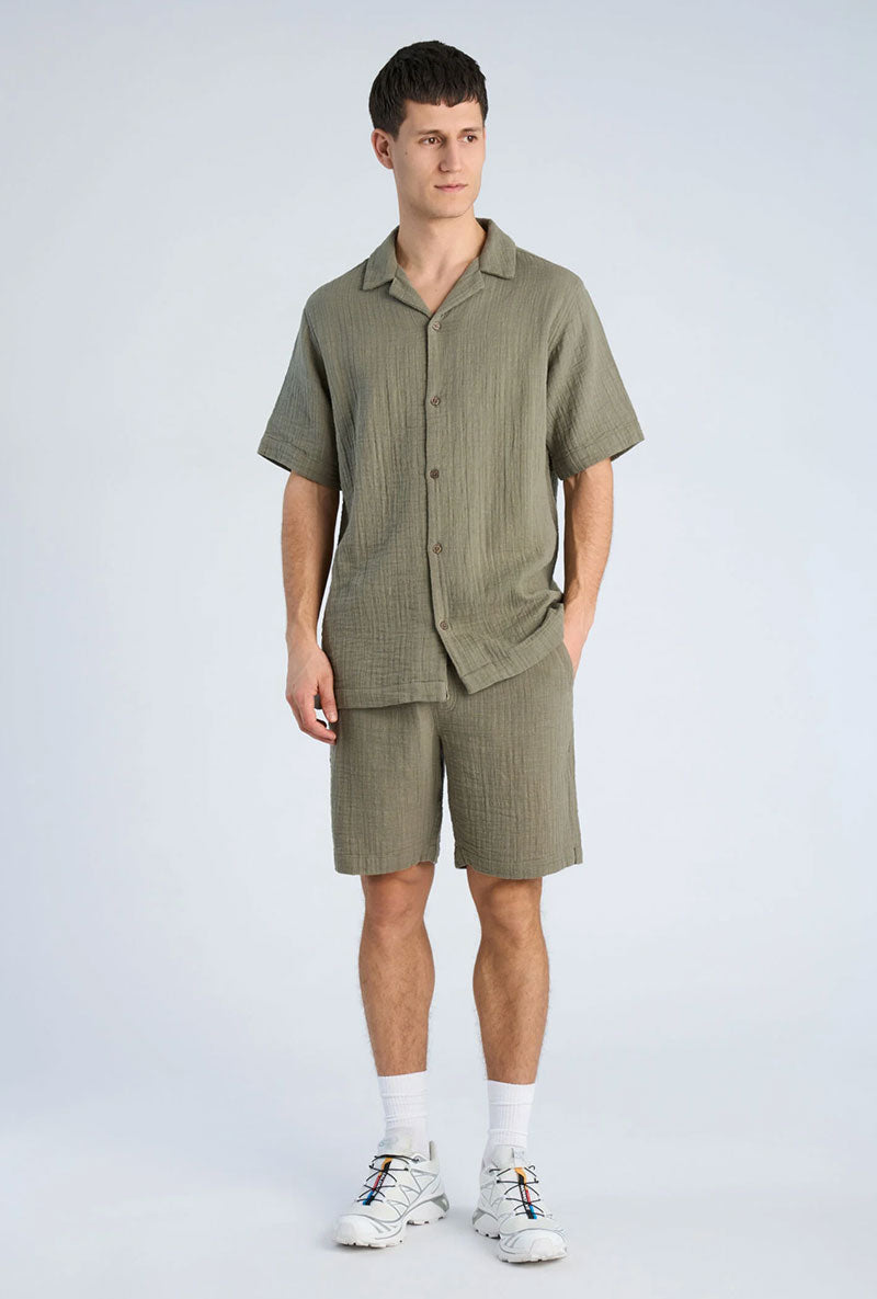 Front image of a model wearing Cotton muslin shorts in sage, by brand Lindbergh