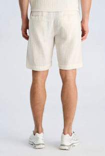Back image of a model wearing the Cotton muslin shorts in off white, by brand Lindbergh