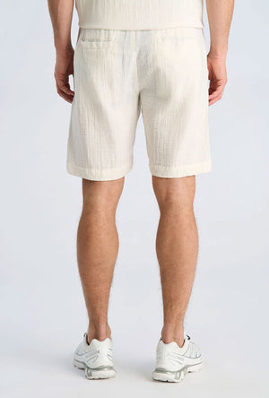 Back image of a model wearing the Cotton muslin shorts in off white, by brand Lindbergh