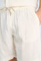 Front image of a model wearing the Cotton muslin shorts in off white, by brand Lindbergh