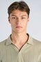 Front image of a model wearing the Jacquard vneck polo in olive, by brand Lindbergh