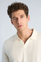 Front image of a model wearing the Jacquard vneck polo in off white, by brand Lindbergh