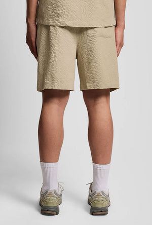 Back image of a model wearing the Crinkle resort shorts in stone, by brand Lyle and scott