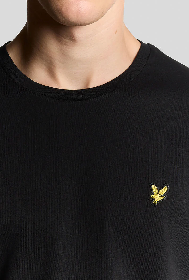 Front neck detail image of a model wearing Plain logo tshirt in black, by brand Lyle and scott