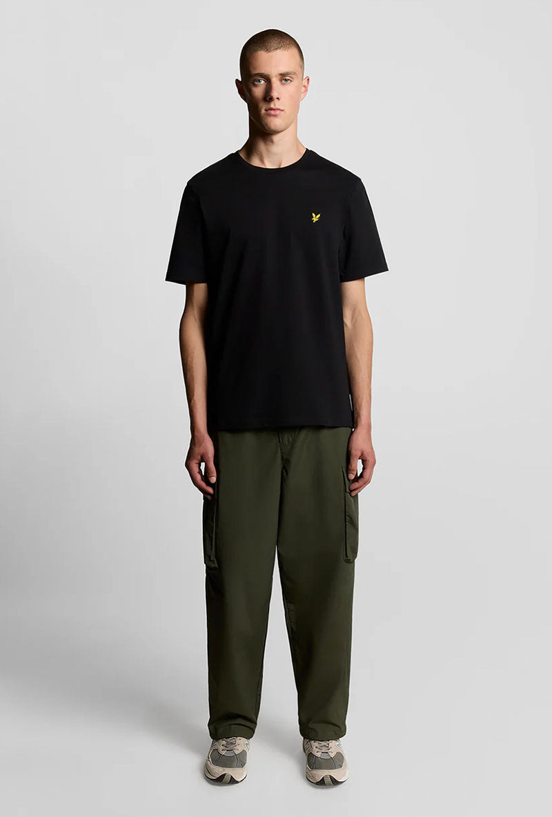 Front image of a model wearing Plain logo tshirt in black, by brand Lyle and scott