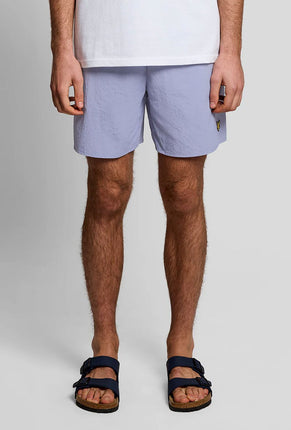 Front image of a model wearing Plain swimshorts in blue, by brand Lyle and scott
