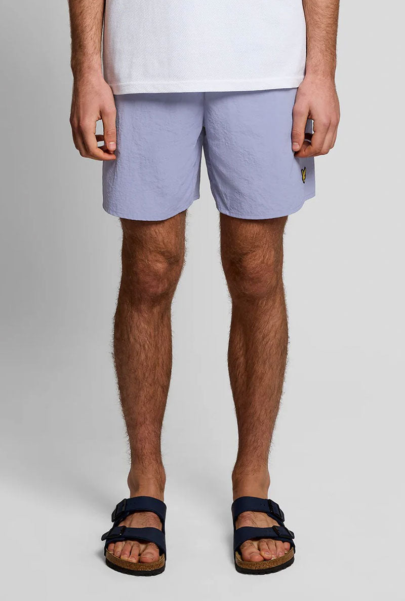 Front image of a model wearing Plain swimshorts in blue, by brand Lyle and scott