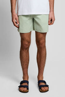Front image of a model wearing the Plain swimshorts in sage, by brand Lyle and scott