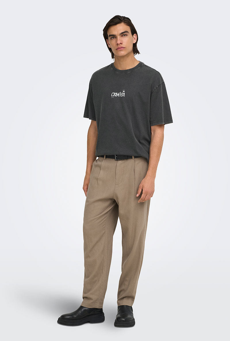 Front image of a model wearing Fred creative washed tee in black, by brand Only and sons