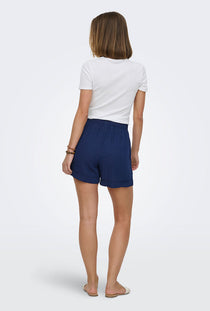Back image of a model wearing the Leoni seersucker pull up shorts in navy, by brand Only