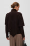 Back image of a model wearing the Camila ls cape higneck pullover in chocolate, by brand Vero moda
