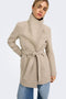 Front image of a model wearing the Trish wrap coat in light brown, by brand Only
