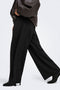 Side image of a model wearing the Yasmine mw pleat barrel pant in black, by brand Only