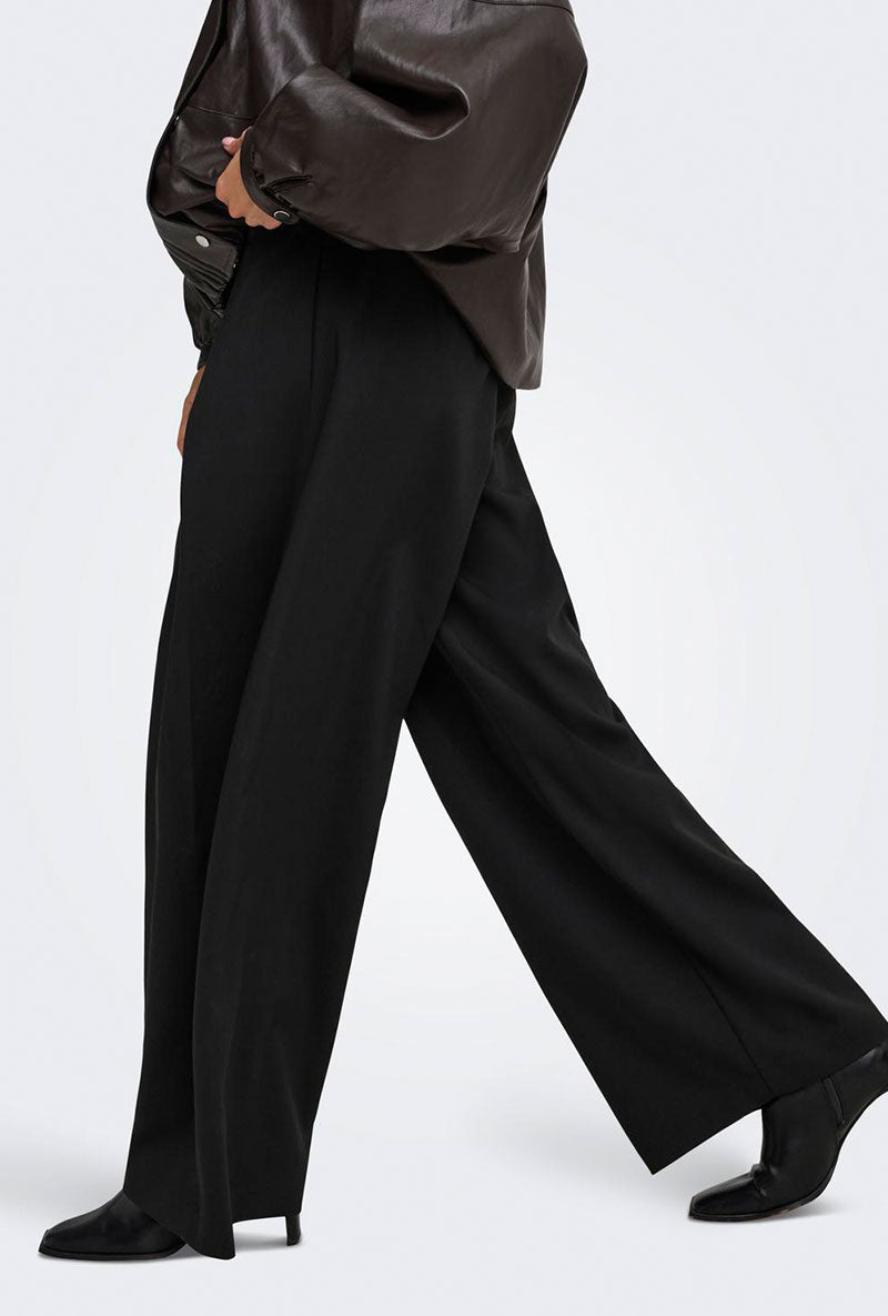 Side image of a model wearing Yasmine mw pleat barrel pant in black, by brand Only