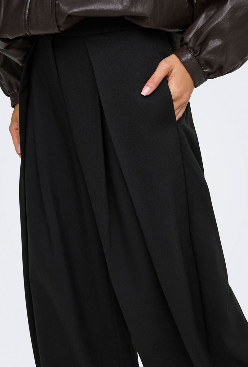 Front image of a model wearing Yasmine mw pleat barrel pant in black, by brand Only