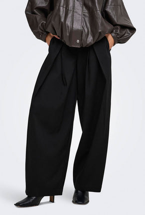 Front image of a model wearing Yasmine mw pleat barrel pant in black, by brand Only