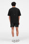 Back image of a model wearing the Micro owners club swimshorts in black, by brand Represent
