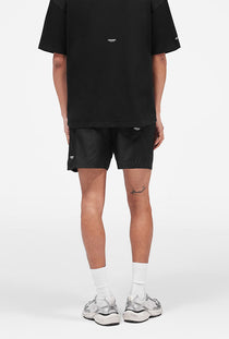 Back image of a model wearing the Micro owners club swimshorts in black, by brand Represent