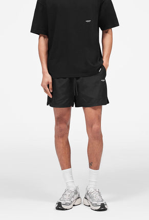 Front image of a model wearing Micro owners club swimshorts in black, by brand Represent