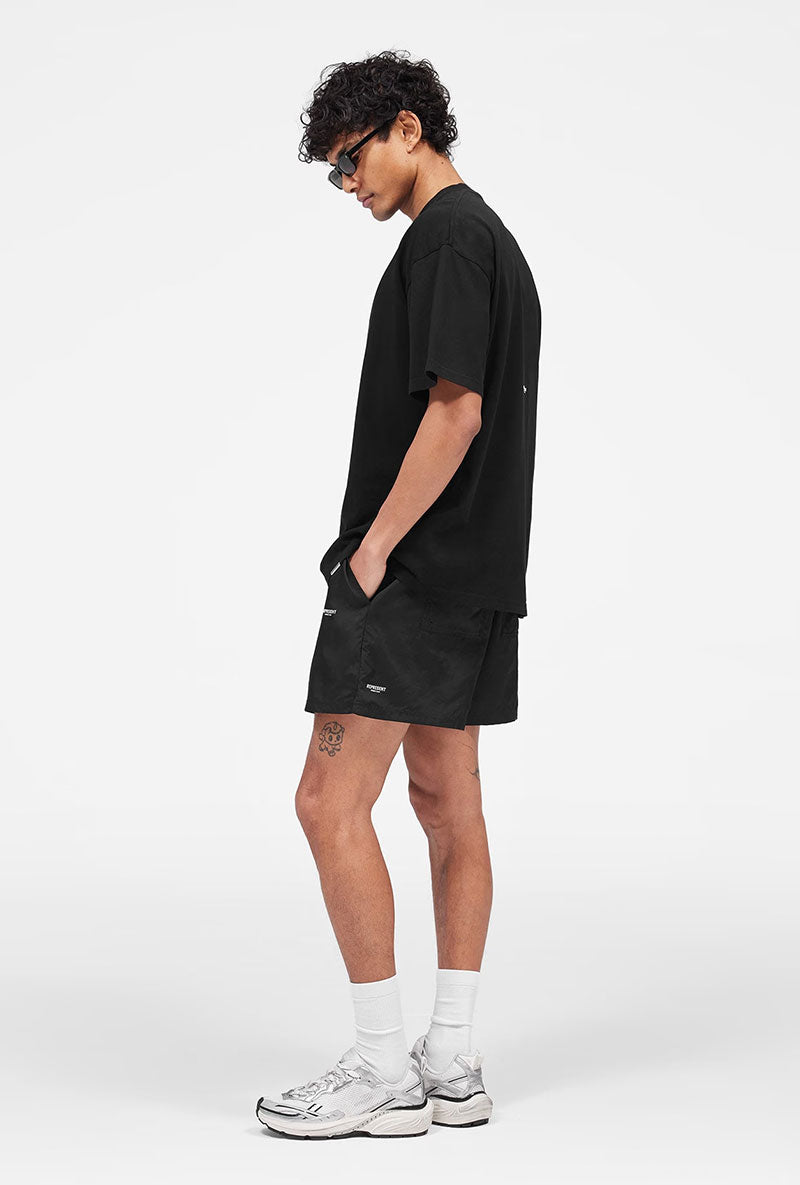Front image of a model wearing Micro owners club swimshorts in black, by brand Represent