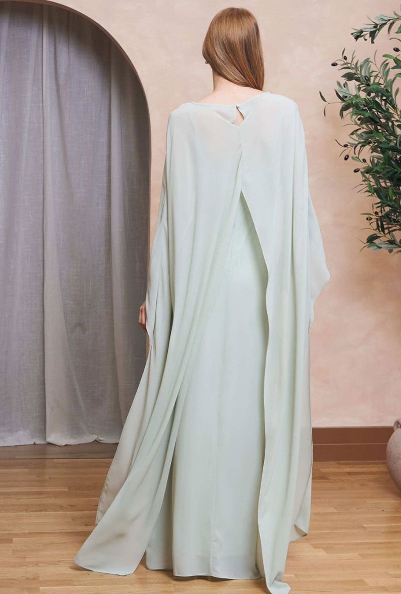 Back image of a model wearing Lailah maxi dress in sage, by brand Tfnc