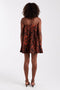 Back image of a model wearing the Calla bandeau mini dress in rust, by brand Top shop