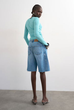Back image of a model wearing the Joa denim barrel jort in denim, by brand Top shop