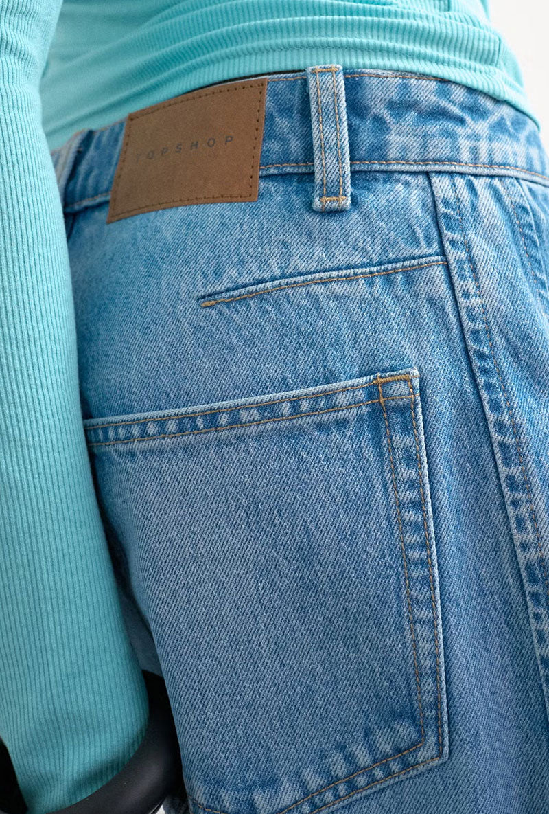 Back image of a model wearing Joa denim barrel jort in denim, by brand Top shop