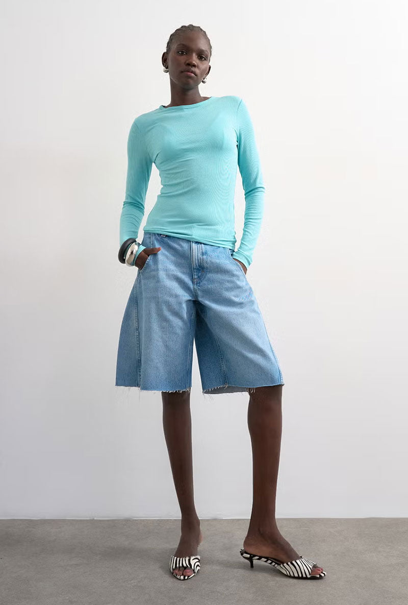 Front image of a model wearing Joa denim barrel jort in denim, by brand Top shop