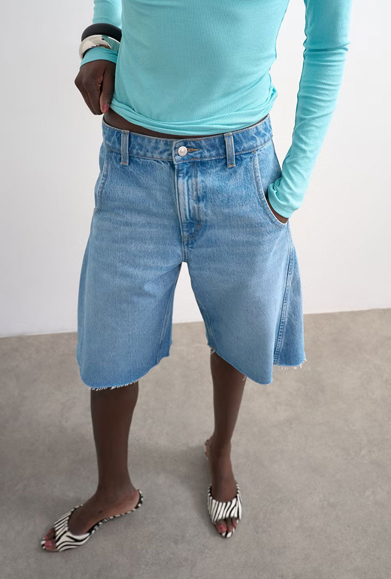 Front image of a model wearing Joa denim barrel jort in denim, by brand Top shop
