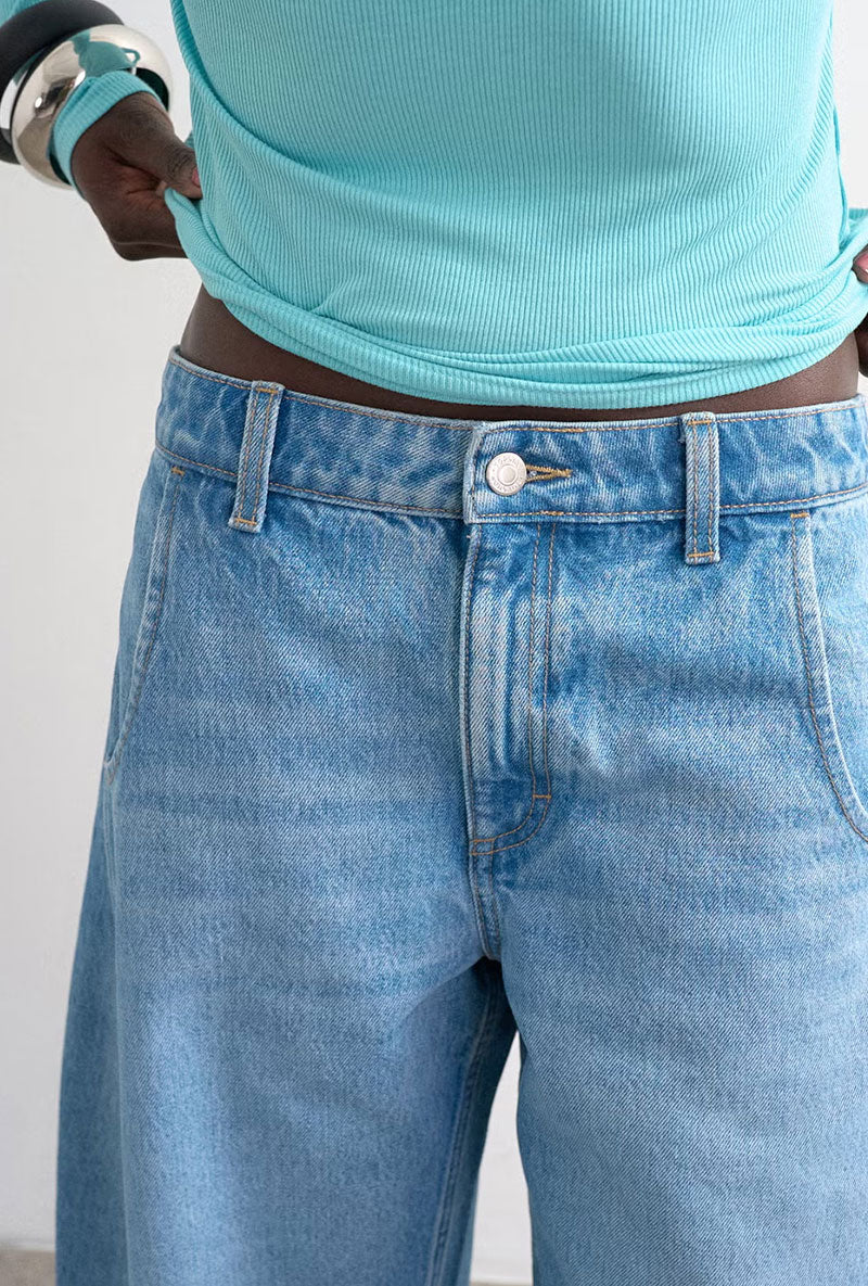 Front image of a model wearing Joa denim barrel jort in denim, by brand Top shop