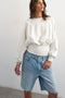 Front image of a model wearing the Rega cinch waist sweatshirt in off white, by brand Top shop