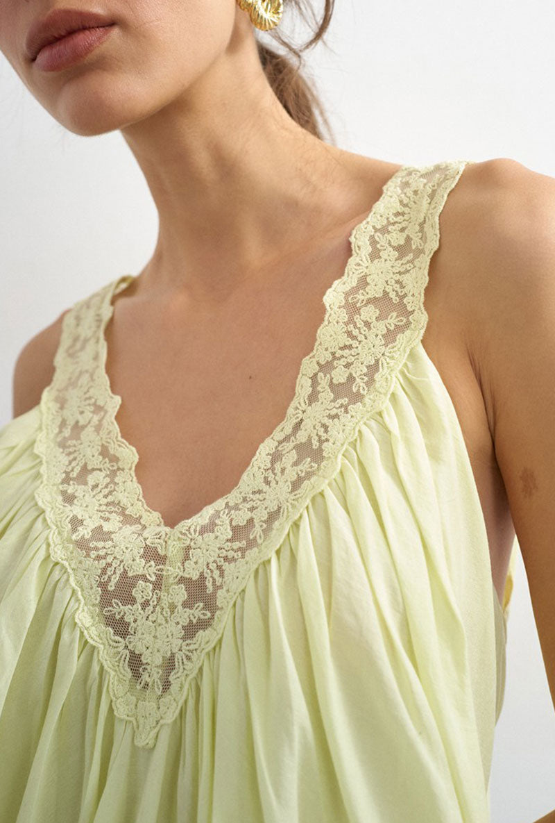 Front image of a model wearing Sophie deep v mini dress in lime, by brand Top shop