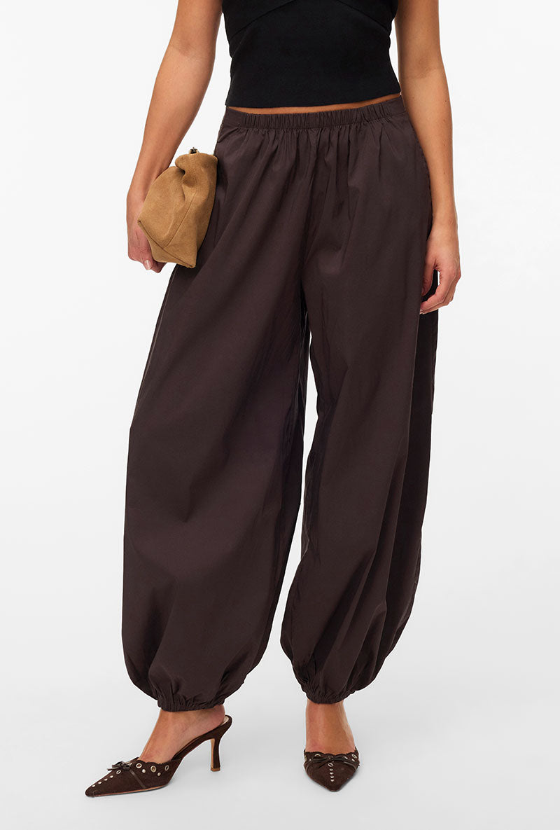 Front image of a model wearing Lotus balloon trousers in chocolate, by brand Vero moda