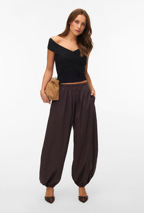 Front image of a model wearing the Lotus balloon trousers in chocolate, by brand Vero moda