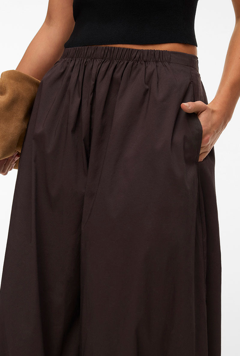 Front image of a model wearing Lotus balloon trousers in chocolate, by brand Vero moda