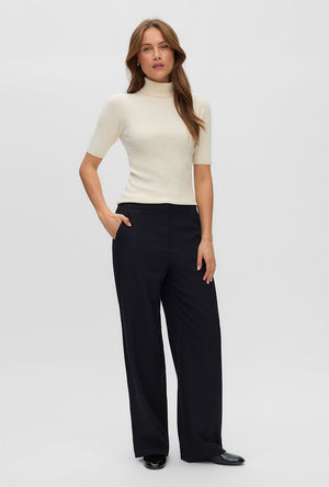 Front image of a model wearing the Eyma rollneck pullover in beige, by brand Vero moda