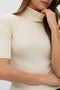 Front image of a model wearing the Eyma rollneck pullover in beige, by brand Vero moda